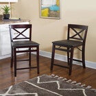 Two bar stools in a living space with geometric rug and wall art in background.