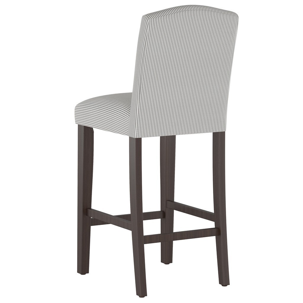 Rear view of a stripe camelback barstool with gray and white striped upholstery and dark wood legs