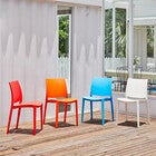 Set of two stackable outdoor dining chairs in white with colorful chairs in background