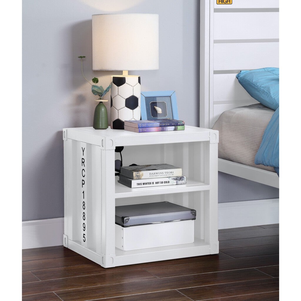 White nightstand with lamp and books in a bedroom