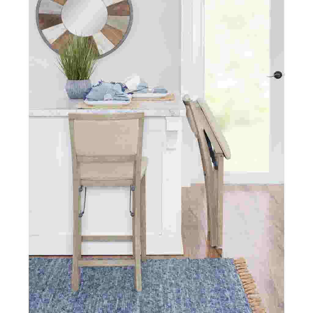 Grey wash folding counter stool in a kitchen with a folded stool in the background