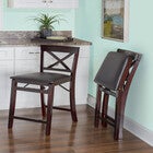 Bar stools placed in a room with additional chair folded, showing X-back design and cushioned seats.