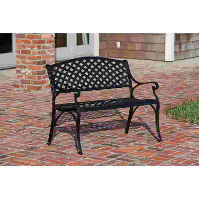 Antique bronze cast aluminum patio bench on a brick patio