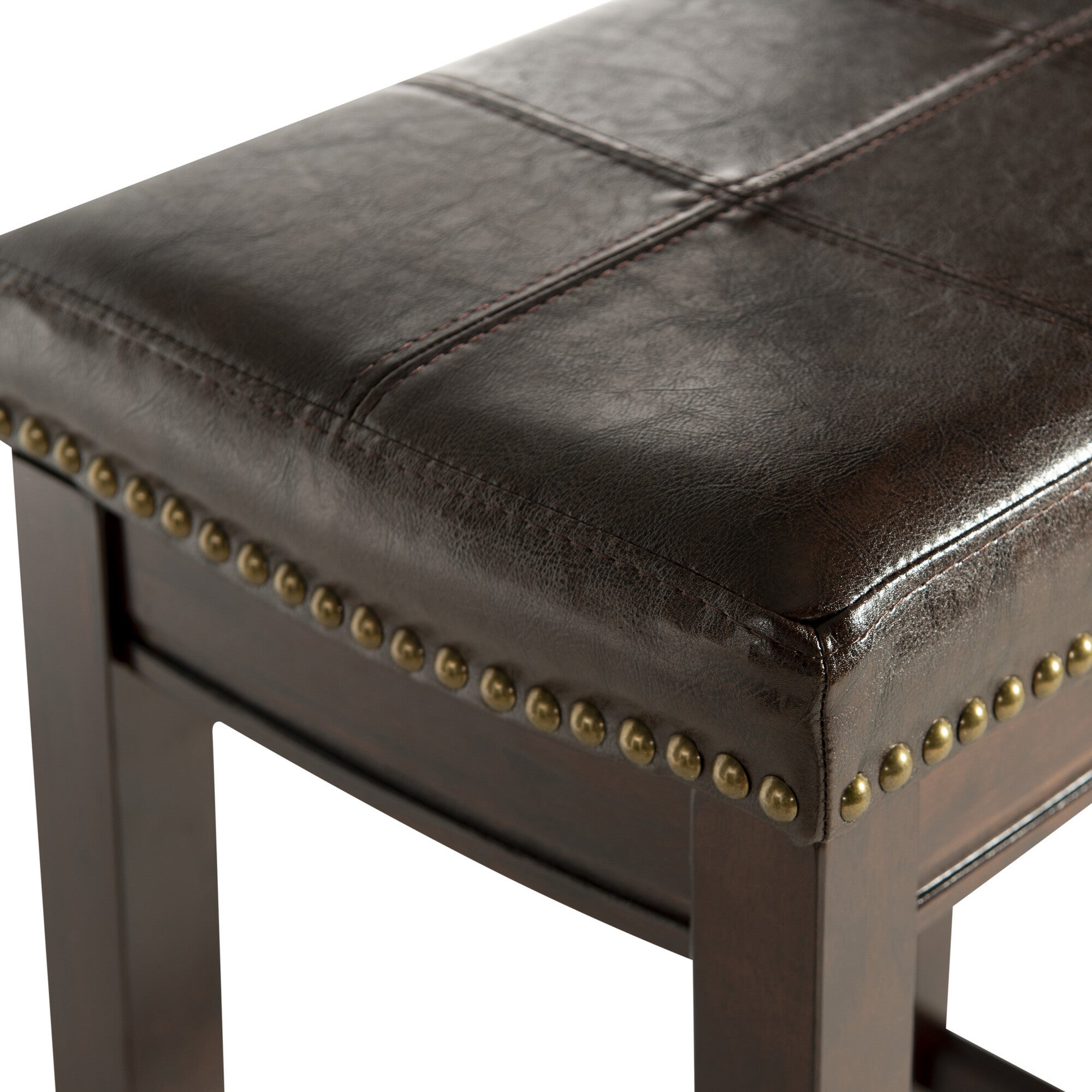 Close-up of dark brown leather-look seat corner and brass nailhead trim