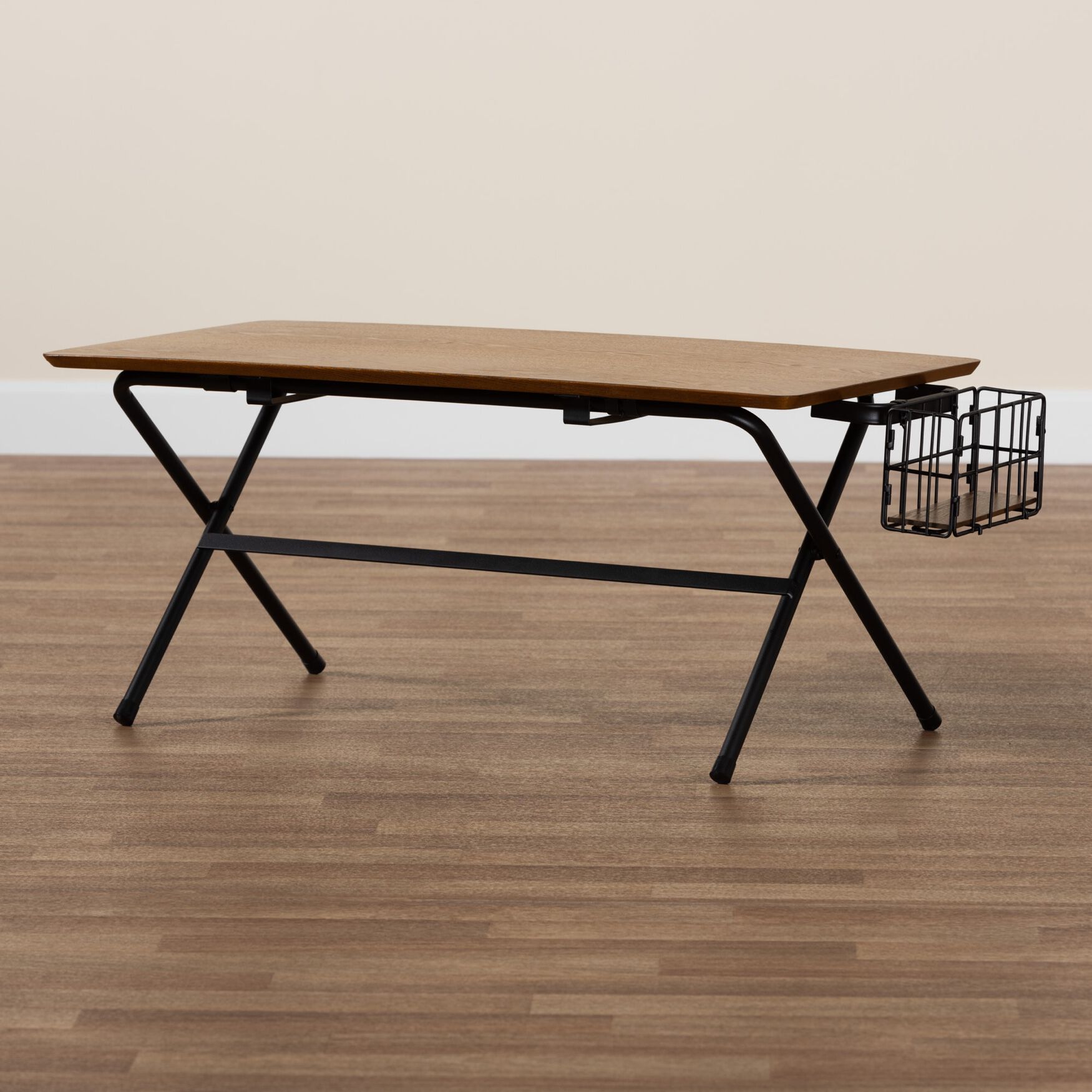 Rectangular coffee table with natural brown wood top and black metal frame, featuring a wire basket on the side, placed on a wooden floor.