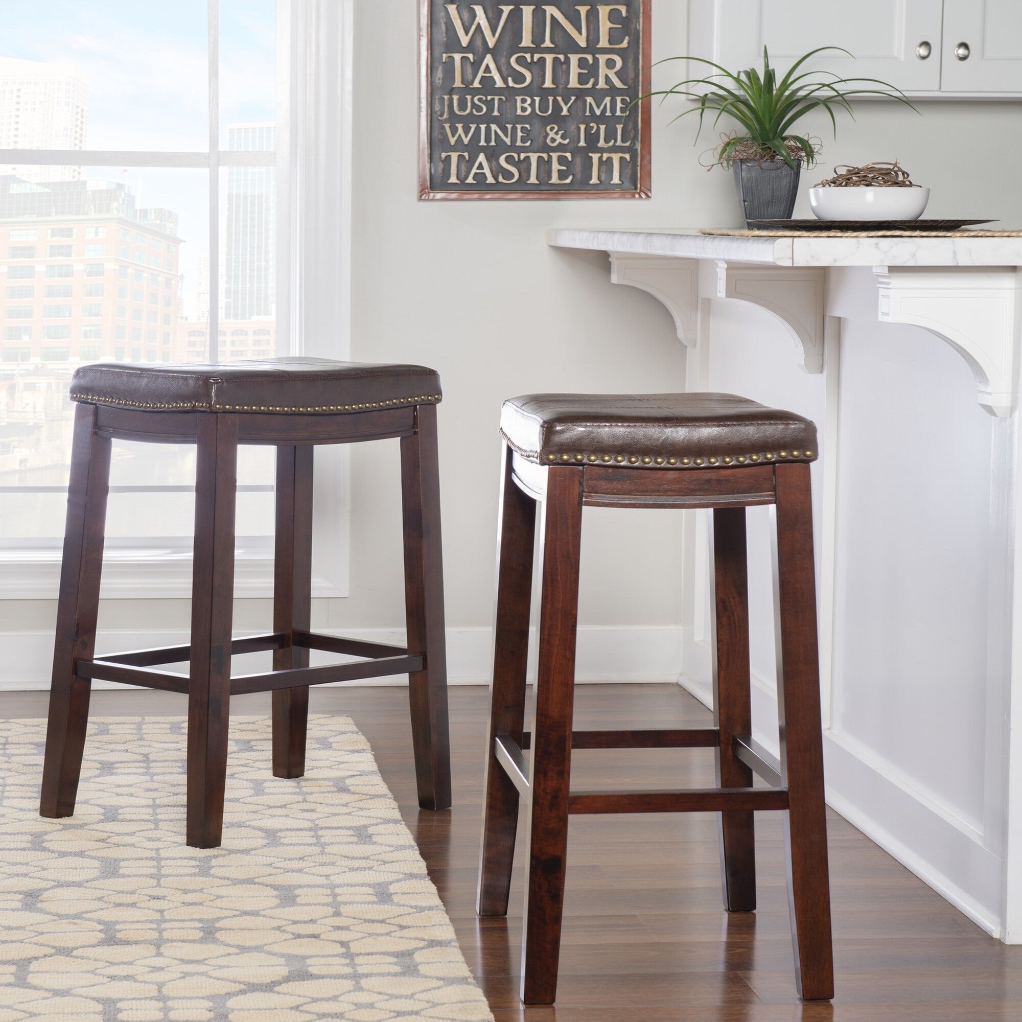Crowell brown bar stool near bar area with dark leather-look seat and nailhead trim