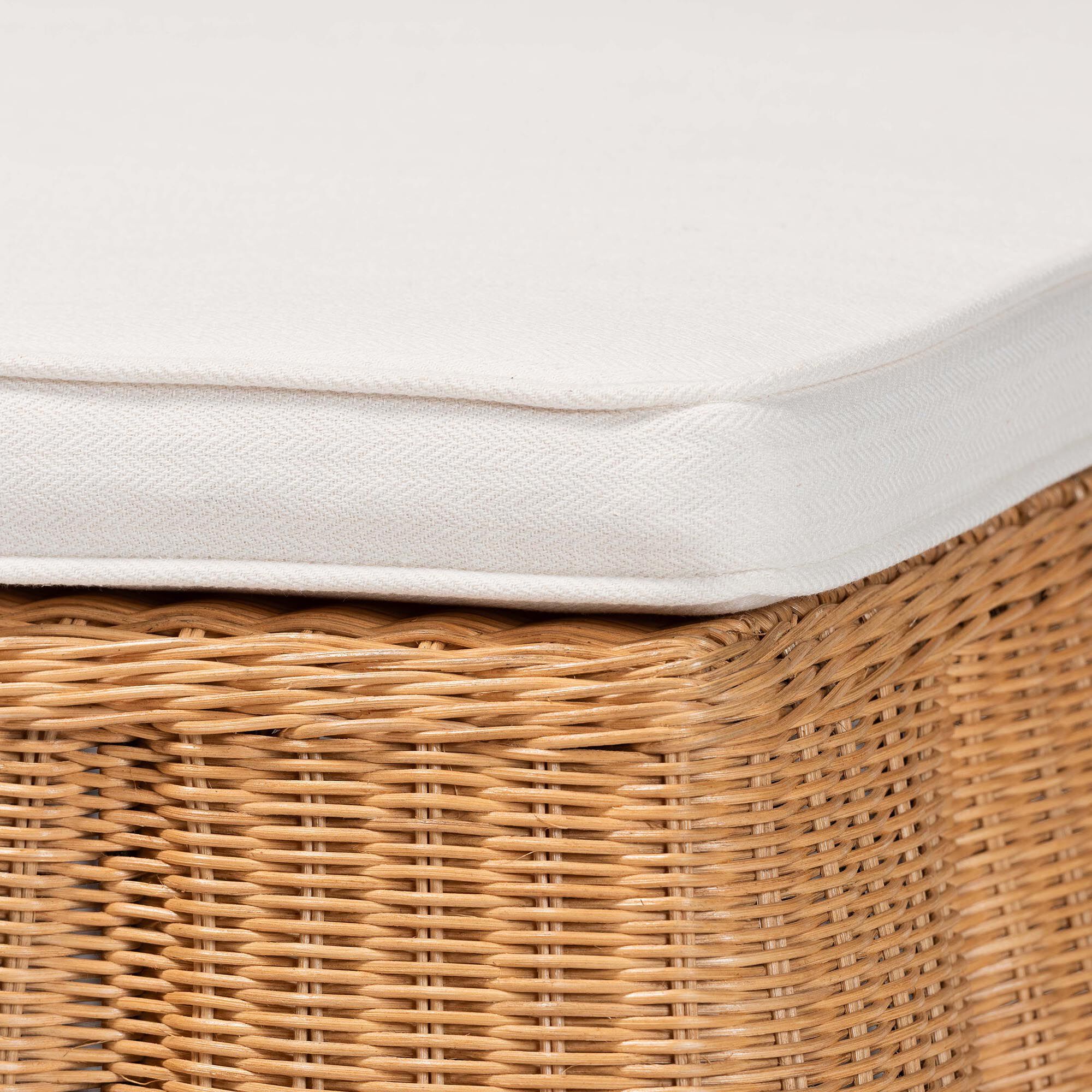 Close-up of white cushion edge and woven rattan ottoman side