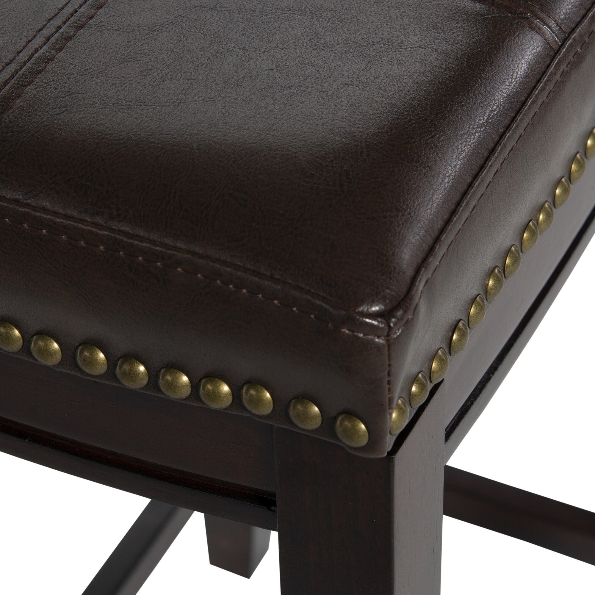 Close-up of dark brown leather-look seat and brass nailhead trim on bar stool