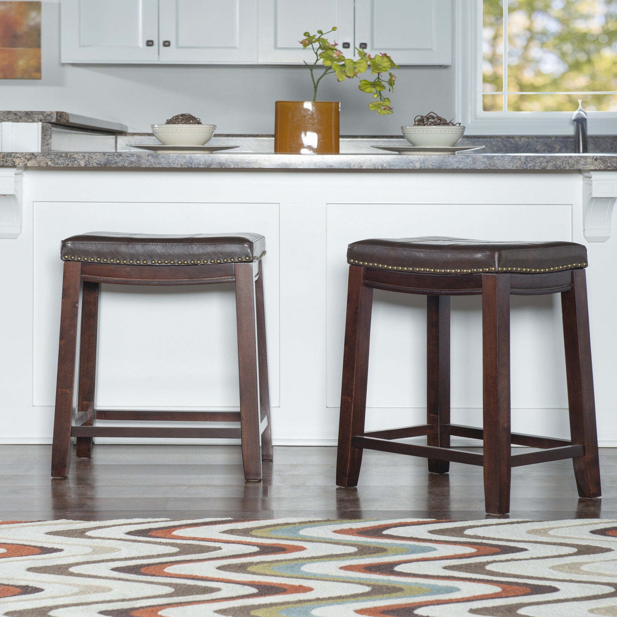 Crowell brown bar stool shown in a kitchen setting with brass nailhead trim