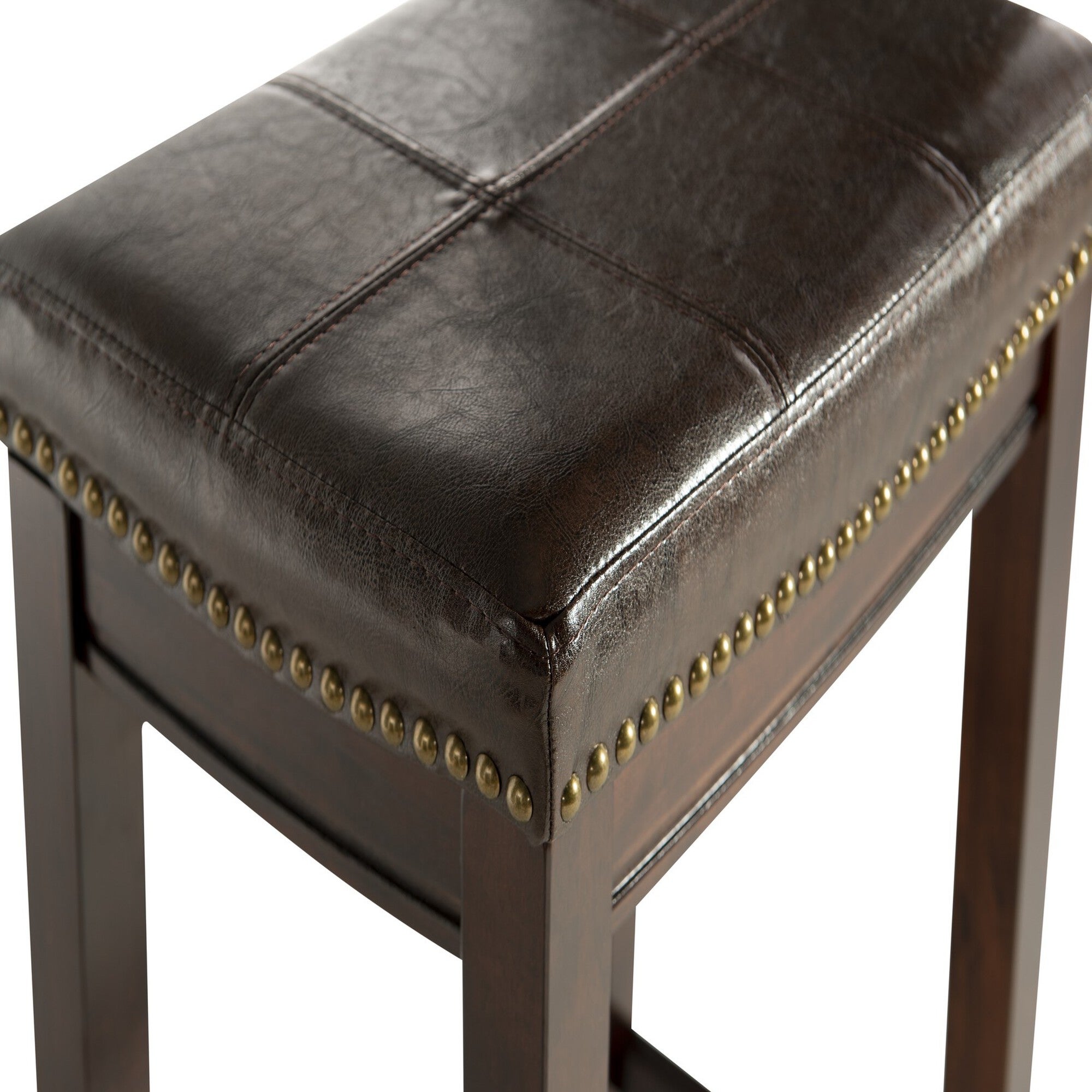 Close-up of dark brown leather-look seat with brass nailhead trim on bar stool