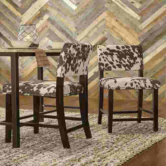 Cypress counter stool with cowhide pattern upholstery and dark wood frame in a dining setting