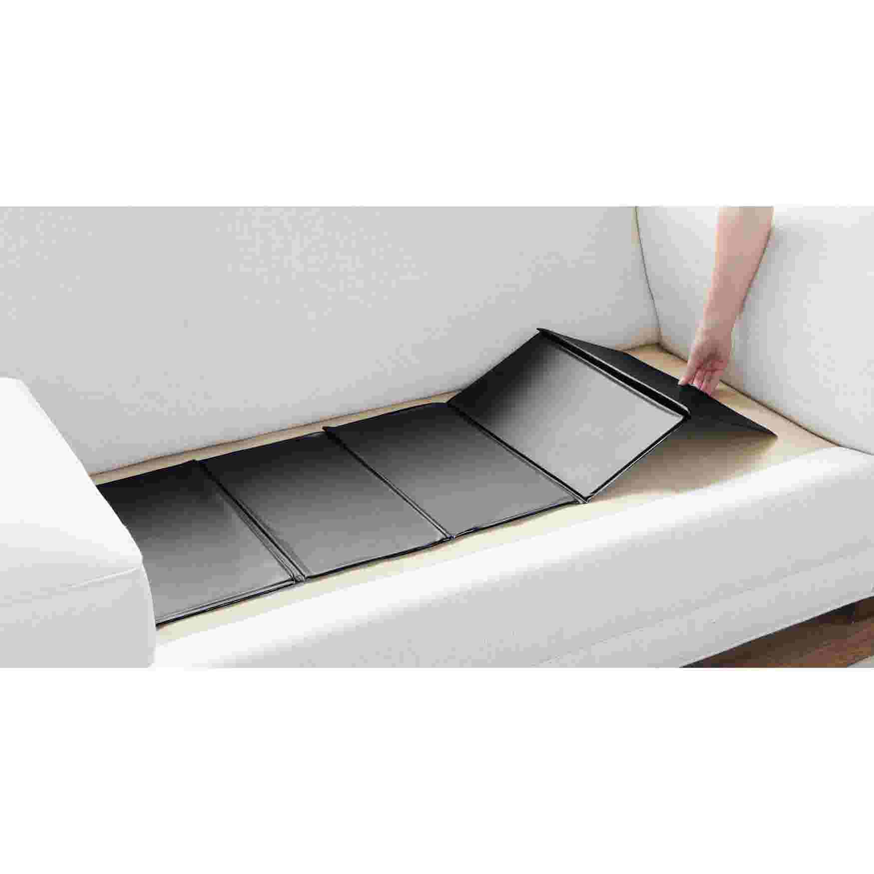 A black sofa cushion support being placed on a white sofa.